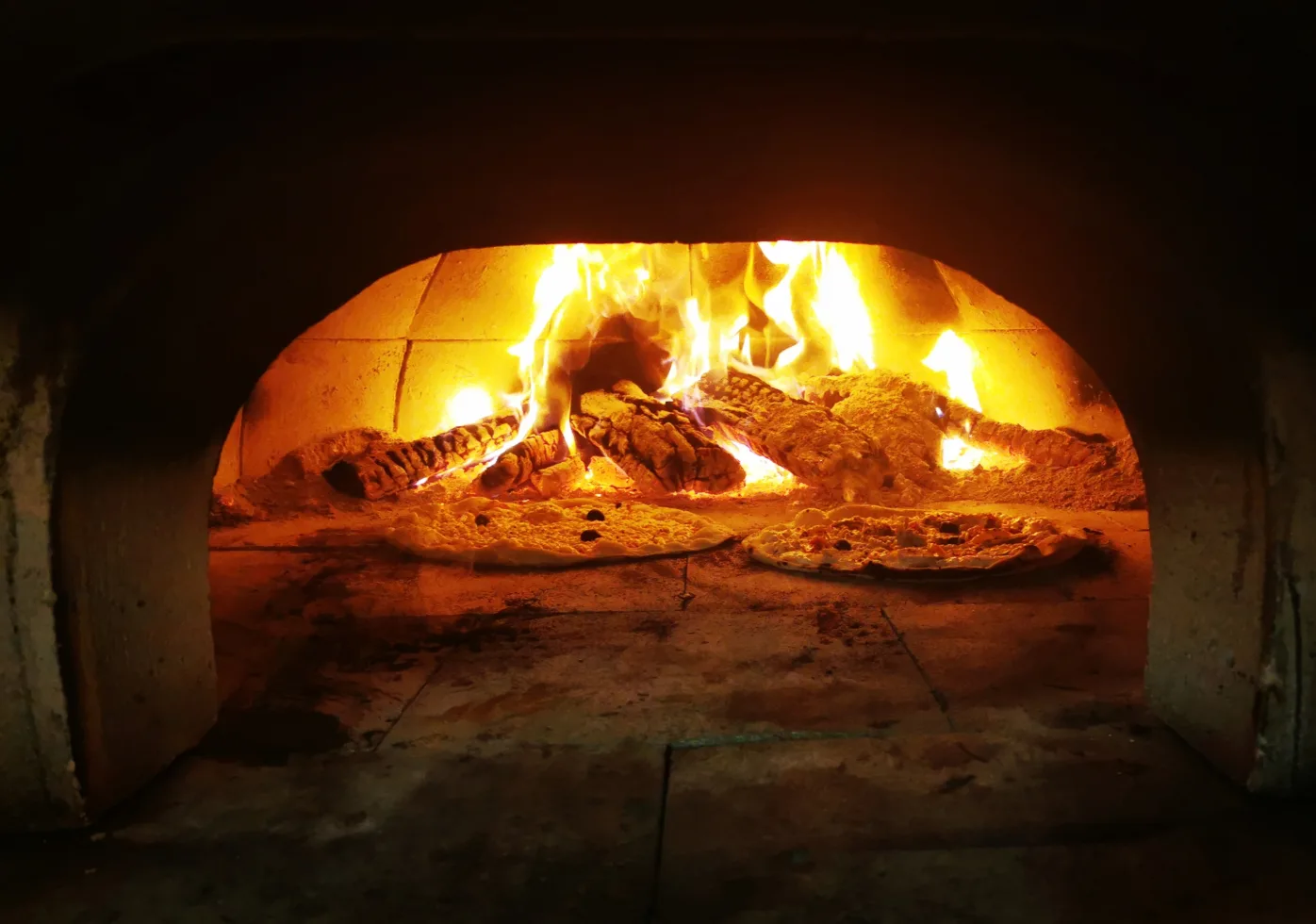 Four à bois de La Fabrique avec des pizzas en cuisson